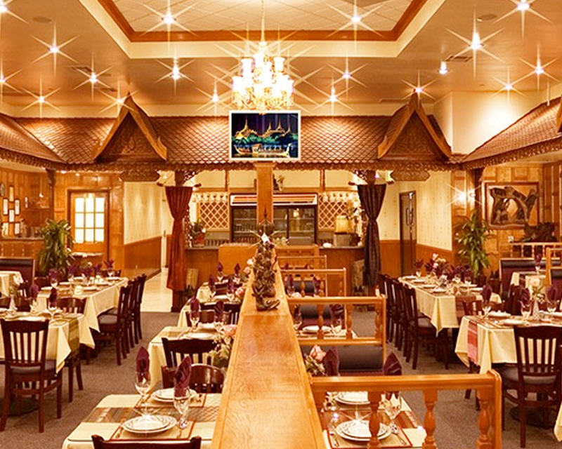 An image of a restaurant prepared for dinner, featuring tables and chairs.